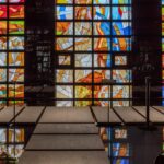 MADE林, Yeongjong-do: The Church That Grew a Forest Colorful stained-glass wall inside a church-like interior on Yeongjong-do, with vibrant geometric panels, glossy black surfaces, and the MADE林 forest-inspired design.
